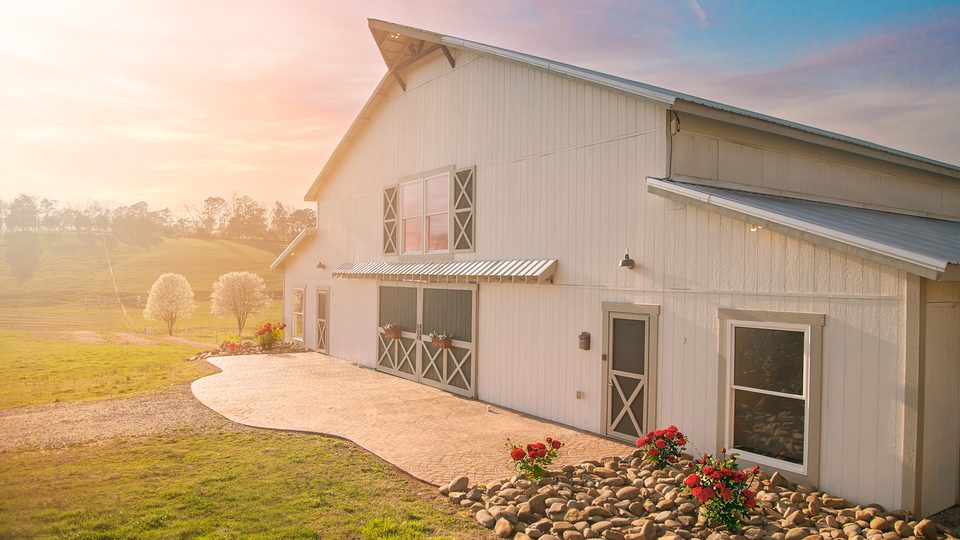 El Grand White Barn a la hora dorada, el granero de recepciones para una boda en granja en las estribaciones de los Smokies