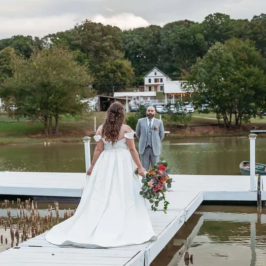 Una novia cruzando el Muelle Flotante sobre el estanque camino a su ceremonia cerca de Knoxville