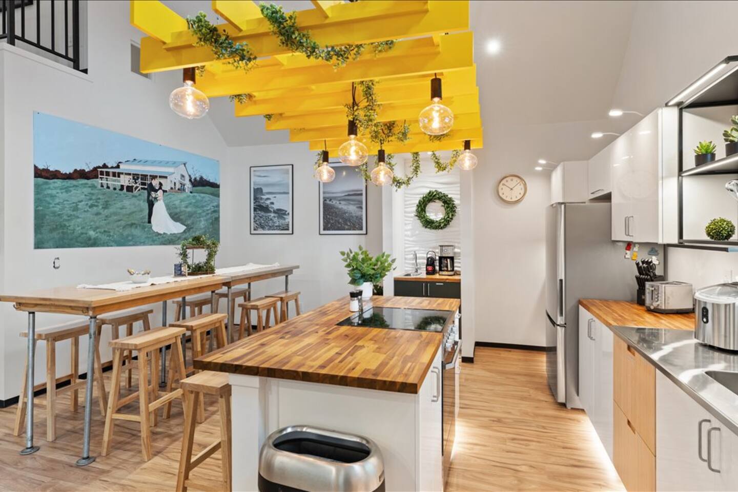 Stylish chef’s kitchen with island, group dining, and bold designer lighting