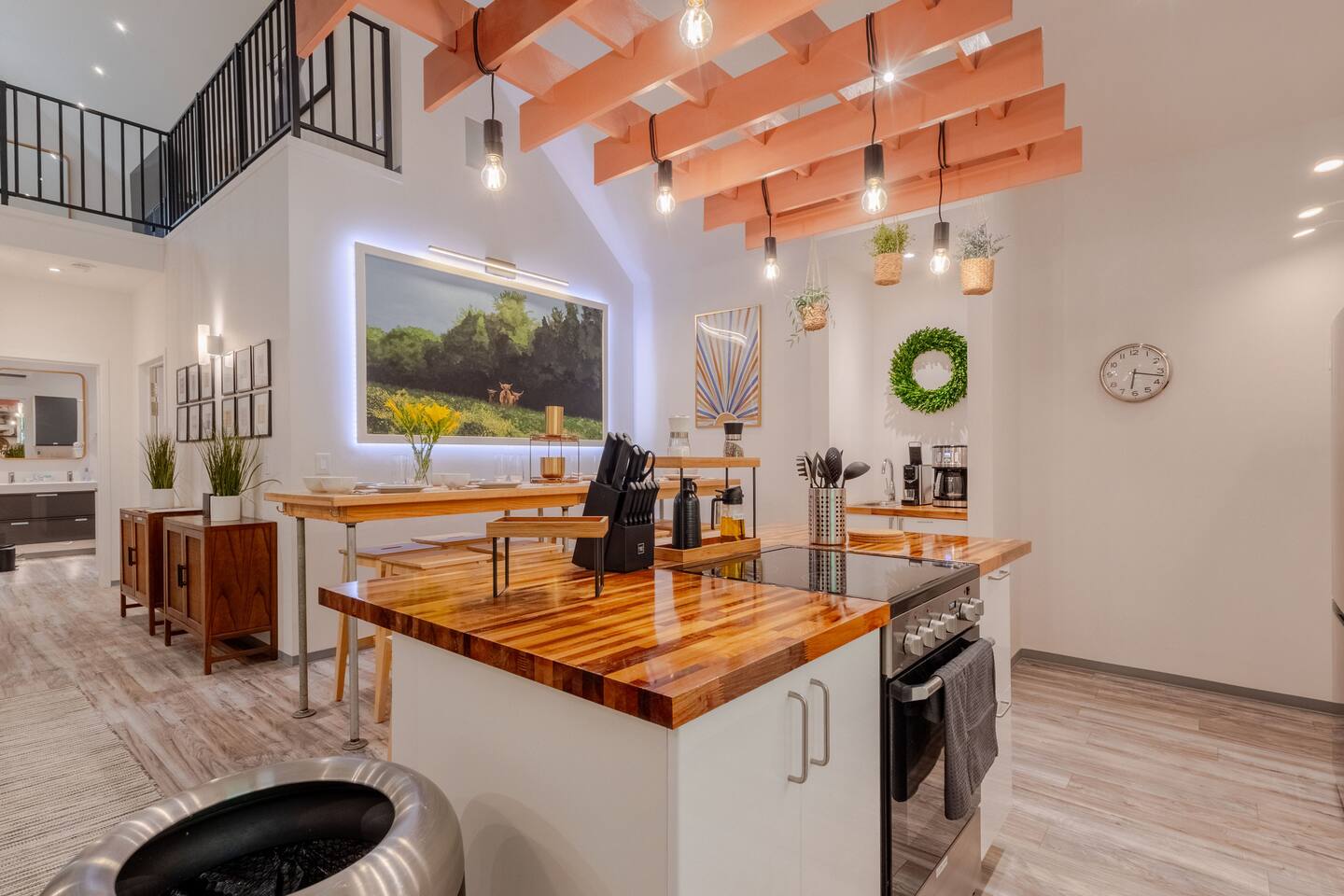 Bright designer kitchen with soaring ceilings, loft views, and warm wood finishes